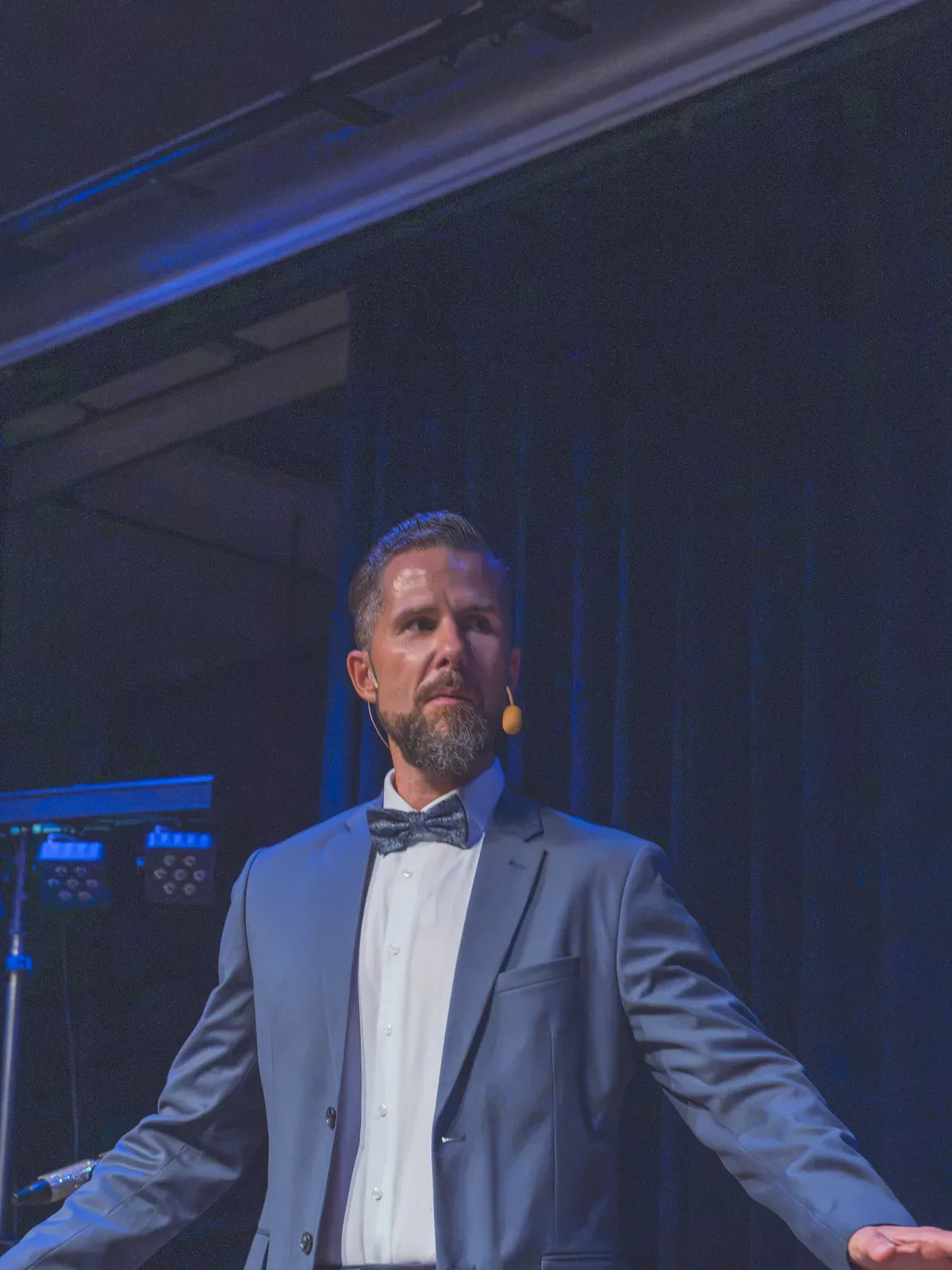 Moderator Stefan Kramberg mit ausgebreiteten Armen auf der Bühne beim Jubiläumsball 125 Jahre Gewerbeverein Rheinfelden