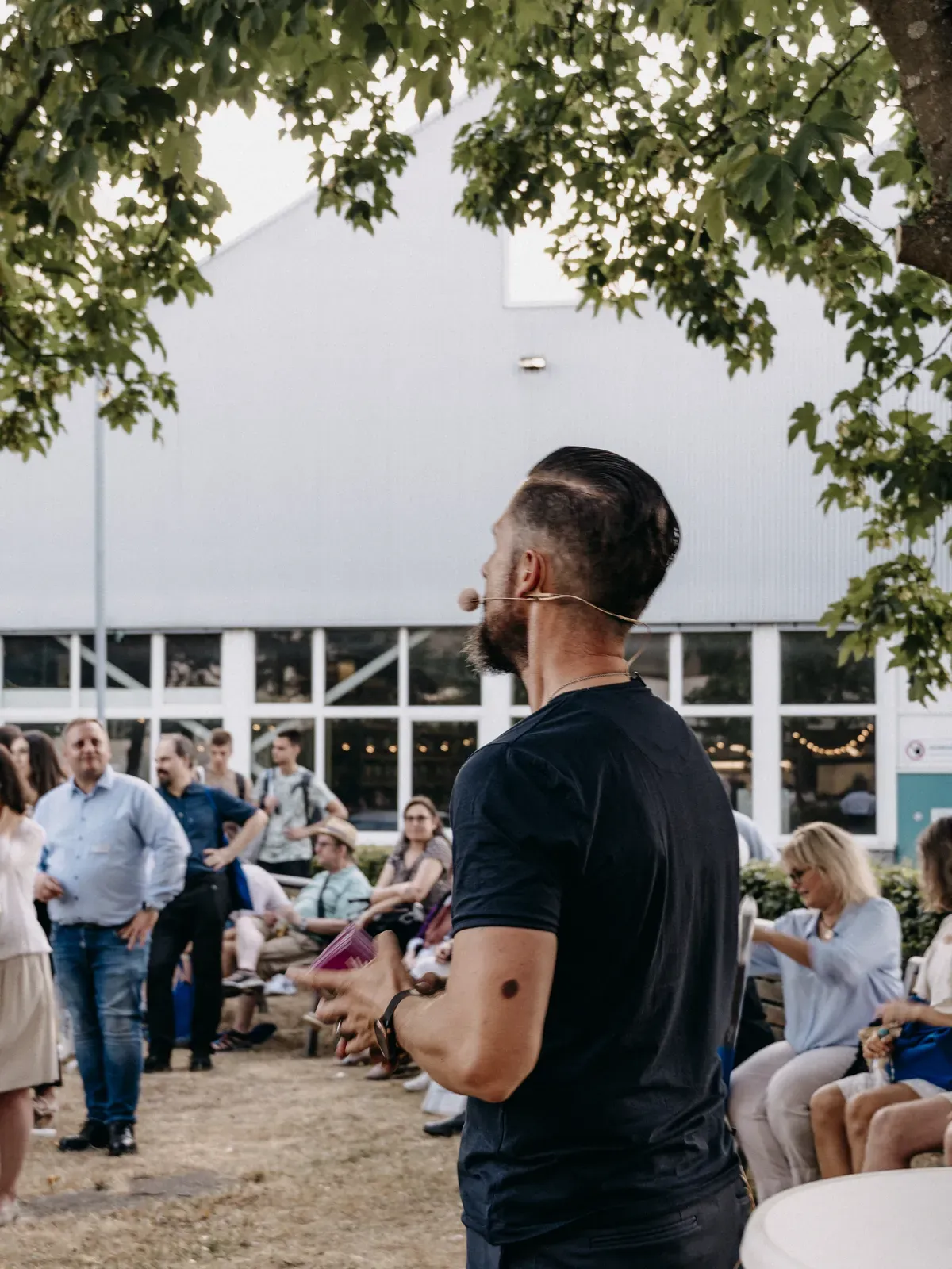 Moderator Stefan Kramberg spricht beim Open-Air-Teil des Jubiläums der bbv Akademie zum Publikum